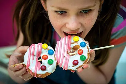 girl eating donutz on a stick