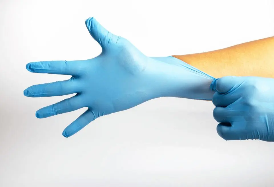 person putting on blue latex gloves